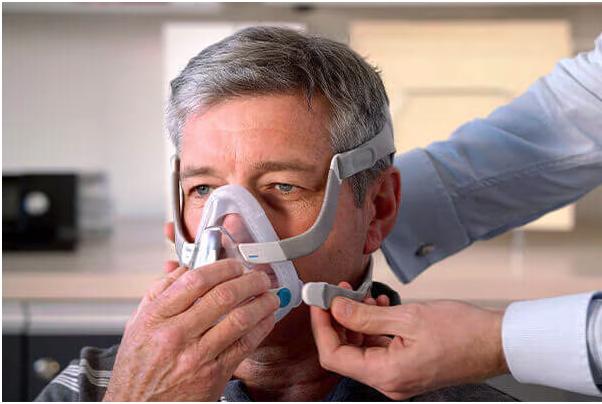 Older man putting on a cpap mask